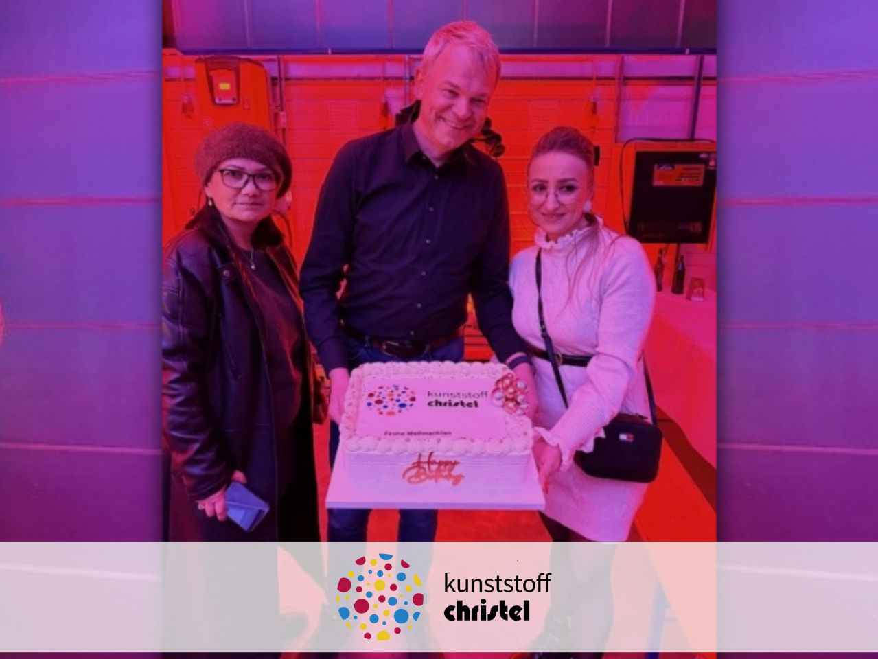 Gruppenbild von der Weihnachtsfeier, Geschäftsführer hält Torte mit unserem Logo