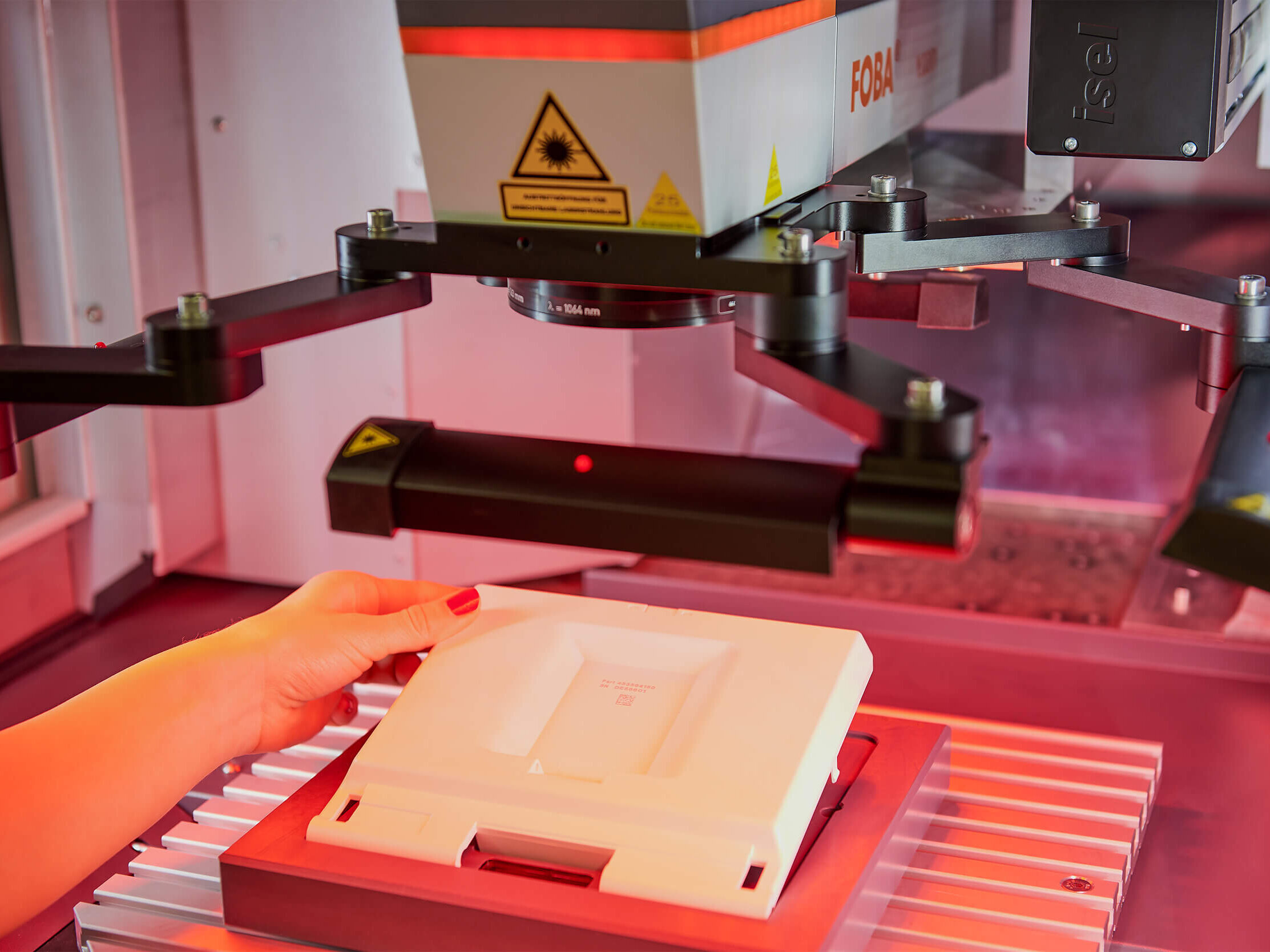 Lasermaschine mit rotem Laser bearbeitet Teil in Vorrichtung