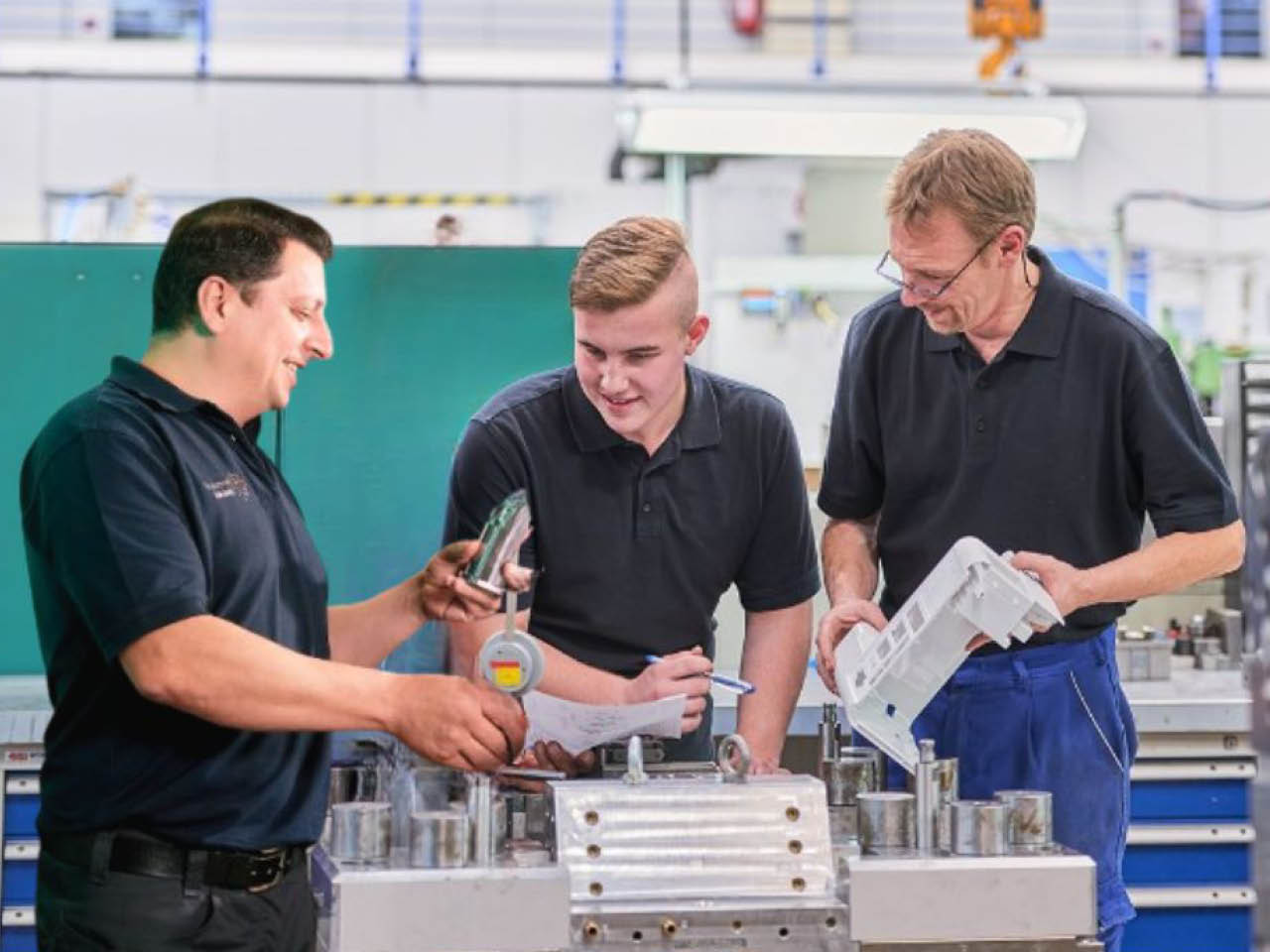 Mitarbeiter aus dem Werkzeugbau erklärt Kollegen etwas